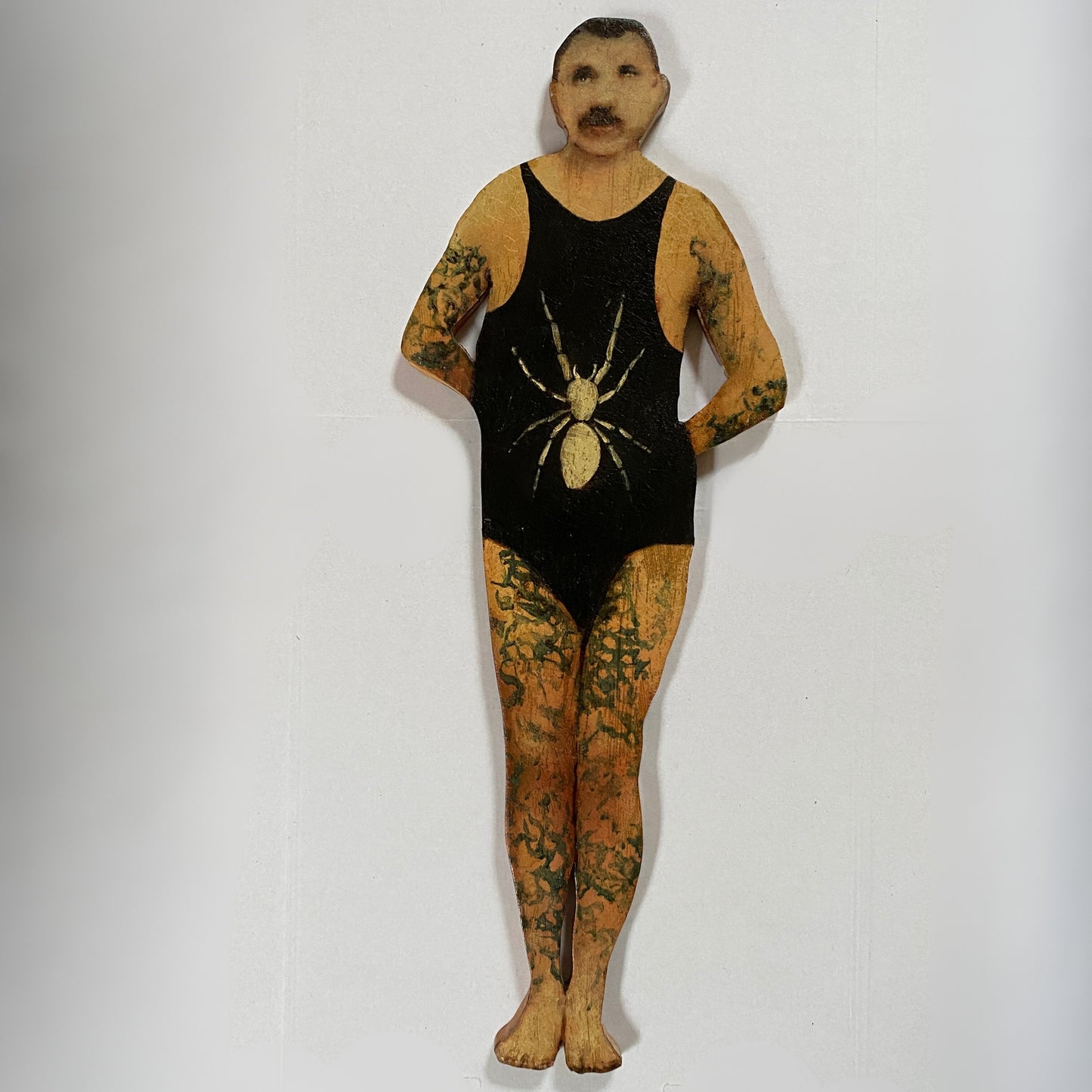 Papillon Man original oil painting on bespoke wood panel, butterfly-themed outsider art with dual-sided narrative, here he's wearing a black swimsuit with a spider design on a white background