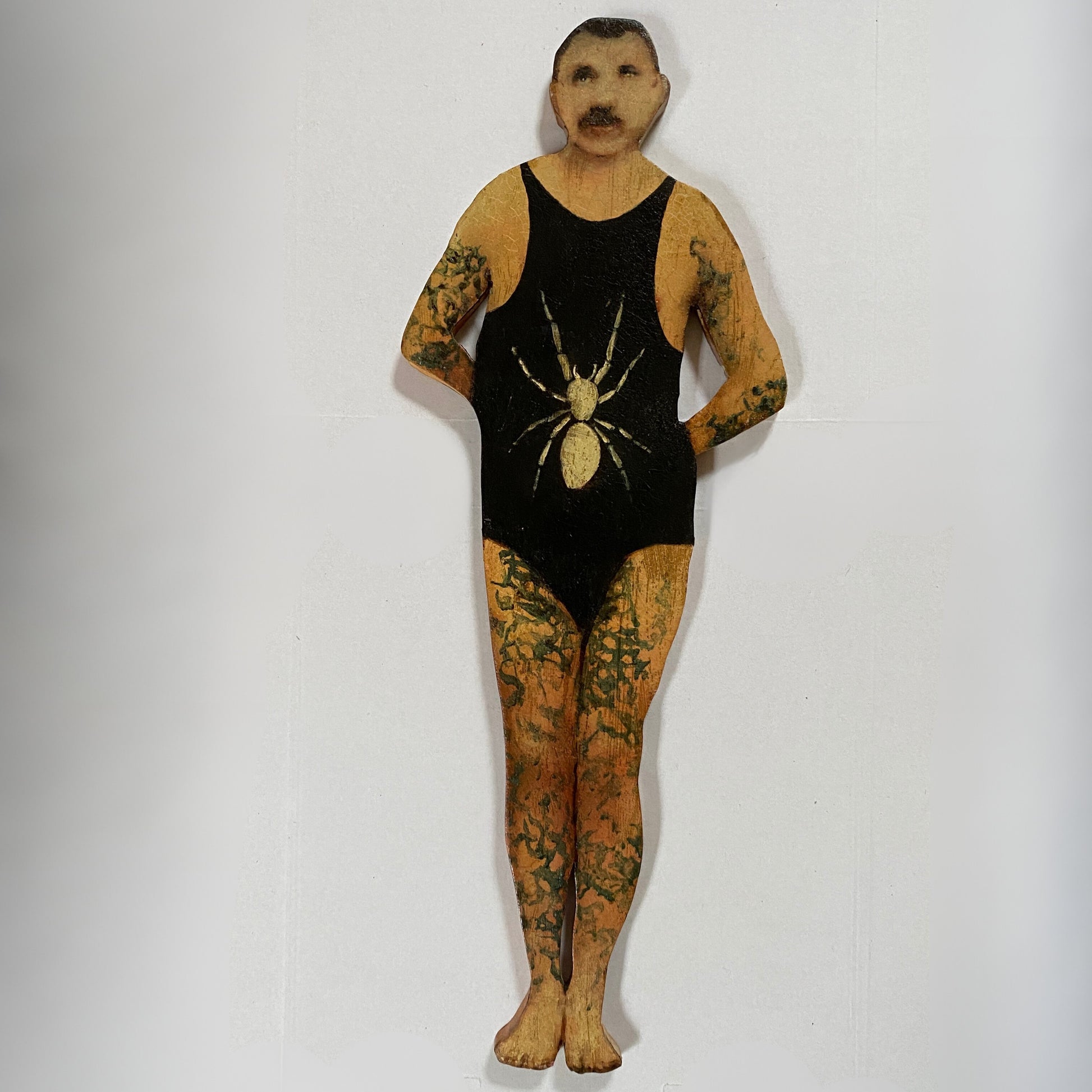 Papillon Man original oil painting on bespoke wood panel, butterfly-themed outsider art with dual-sided narrative, here he's wearing a black swimsuit with a spider design on a white background